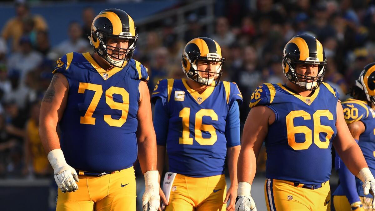 Rams tackle Rob Havenstein (79) stands with Rams quarterback Jared Goff (16) and Austin Blythe at the Coliseum.