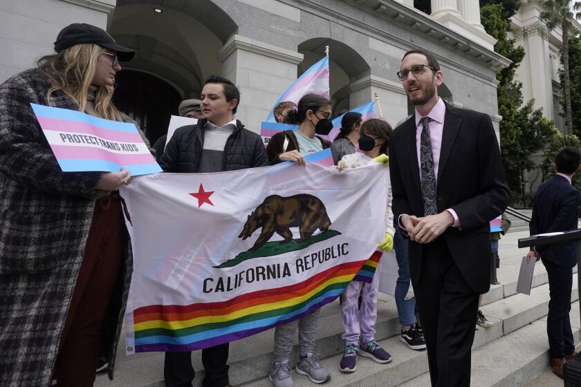 FILE—State Sen. Scott Wiener, D-San Francisco, right, prepares to announce his proposed measure to provide legal refuge to displaced transgender youth and their families during a news conference in Sacramento, Calif., Thursday, March 17, 2022. On Thursday, Sept. 29, 2022, Gov. Gavin Newsom signed Wiener's bill into law. (AP Photo/Rich Pedroncelli, File)