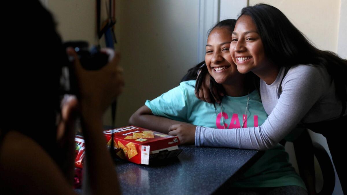 Ellie Perez, 16, left, photographs sisters Maquisha, 12, and Dashly, 14, at their home in Los Angeles.