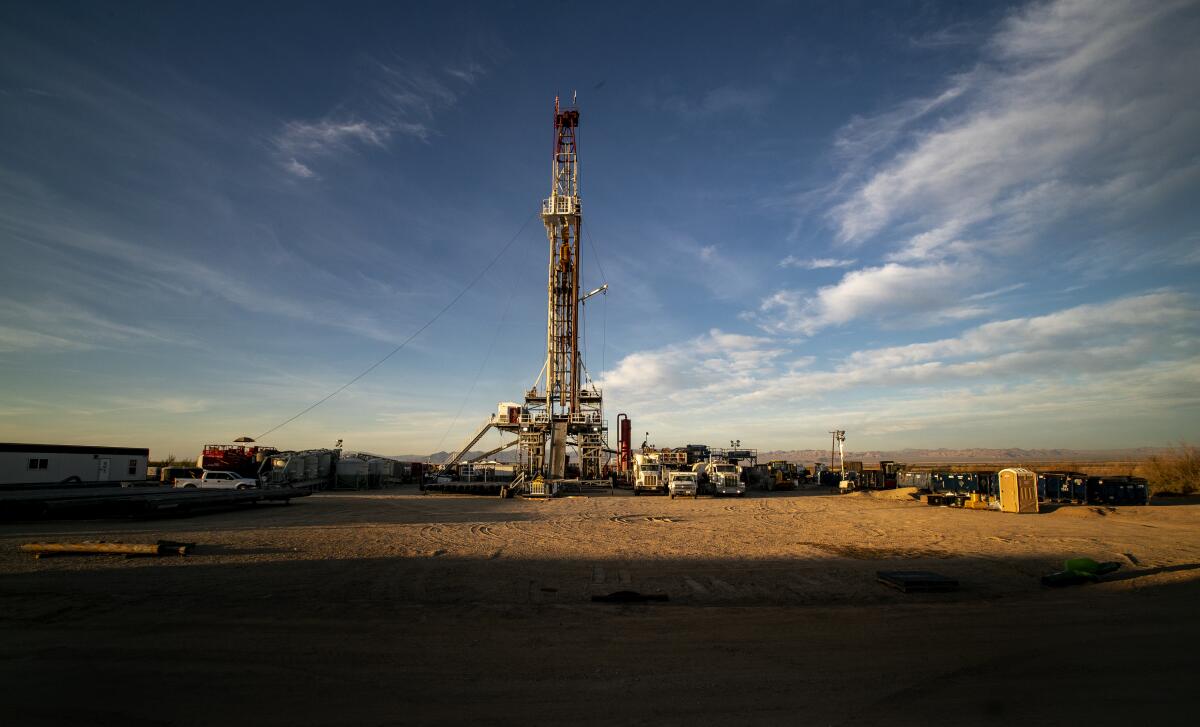 A drill rig with vehicles near it.