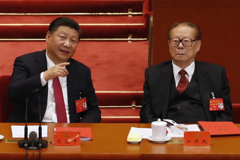 FILE - Chinese President Xi Jinping, left, chats with former President Jiang Zemin during the closing ceremony for the 19th Party Congress at the Great Hall of the People in Beijing, on Oct. 24, 2017. With his death, Jiang leaves behind a very different China than the one he tried to shape. Now it’s Xi Jinping’s nation. (AP Photo/Andy Wong, File)