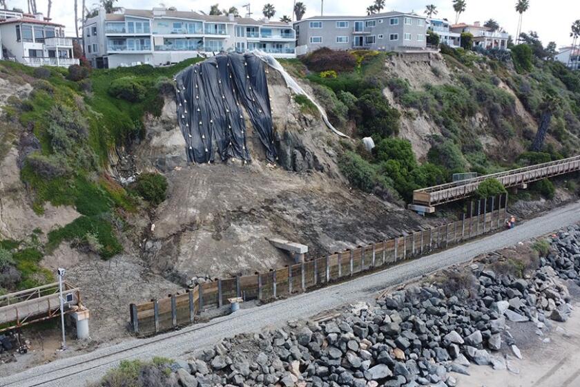 Work nears completion on a wall built to protect the railroad tracks below a landslide in San Clemente.