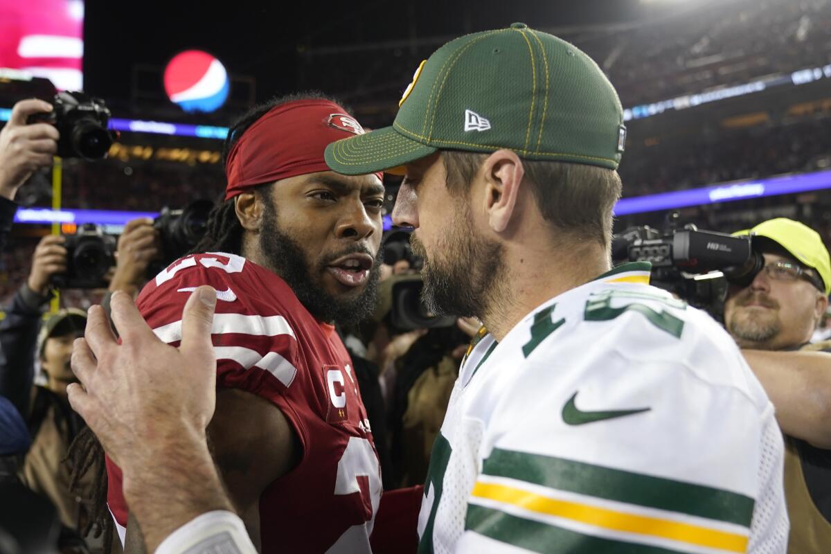 FILE - In this Nov. 24, 2019, file photo, San Francisco 49ers cornerback Richard Sherman, left, greets Green Bay Packers quarterback Aaron Rodgers after an NFL football game in Santa Clara, Calif. Two of the best at their jobs will meet once again in the NFC championship game when Green Bay quarterback Aaron Rodgers must decide how much to challenge San Francisco cornerback Richard Sherman. (AP Photo/Tony Avelar, File)