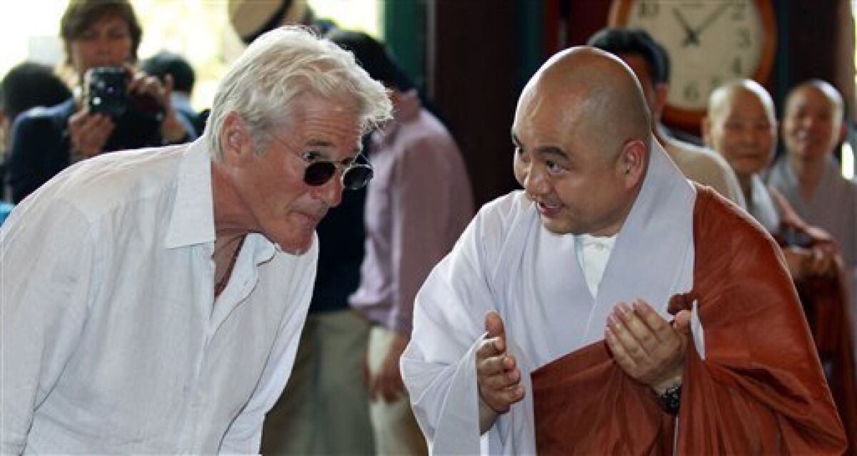 U.S. actor Richard Gere, left, listens to monk Sung Jin during his visit to the Korean Buddhism's Chogye temple in Seoul, South Korea, Tuesday, June 21, 2011. Gere is in South Korea for six days to promote his photo exhibition and tour Buddhist temples. (AP Photo/ Lee Jin-man, Pool)