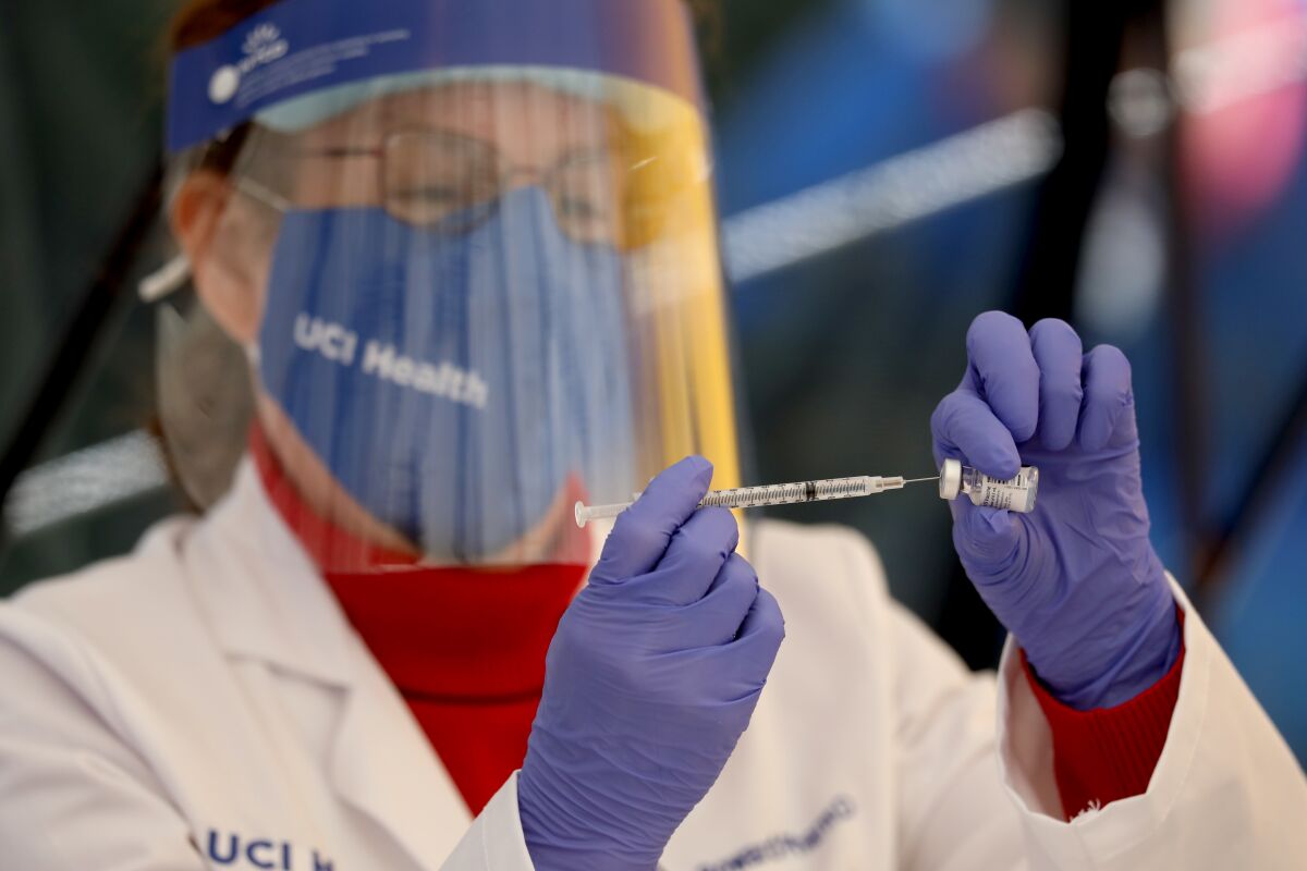 A nurse at UCI Health prepares a COVID-19 vaccine dose.