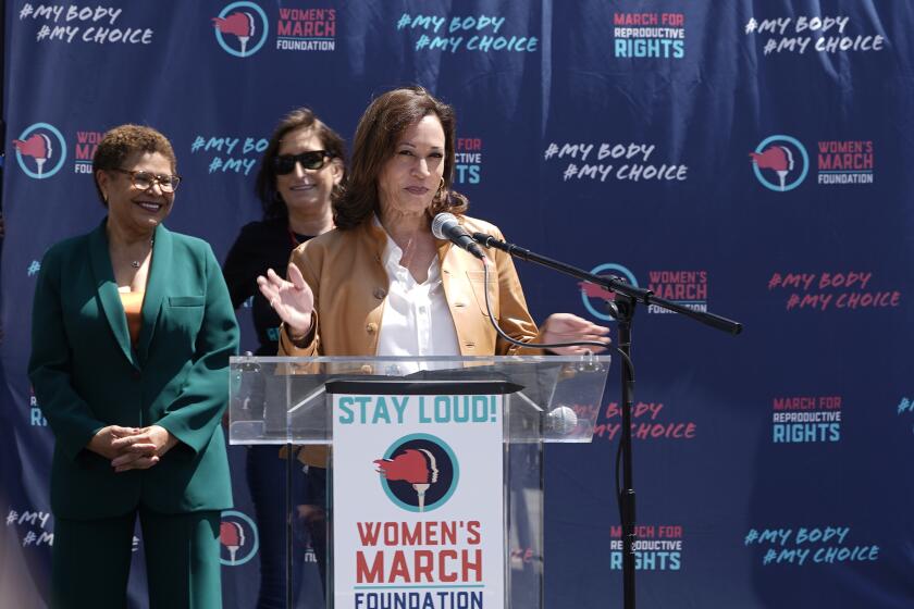 Vice President Kamala Harris, at podium, is welcomed on stage by Los Angeles Mayor Karen Bass, far left, 