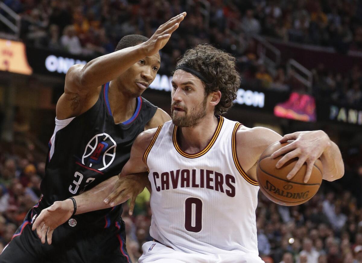 Clippers forward Wesley Johnson tries to cut off a drive by Cavaliers forward Kevin Love during the first half.