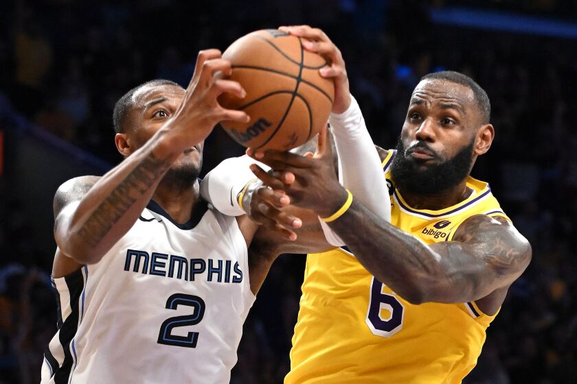 Los Angeles, California April 24, 2023-Lakers LeBron James and Grizzlies Xavier Tillman Sr. battle or loose ball in overtime in Game 4 of the NBA playoffs at Crypto.com arena Monday. (Wally Skalij/Los Angeles Times)