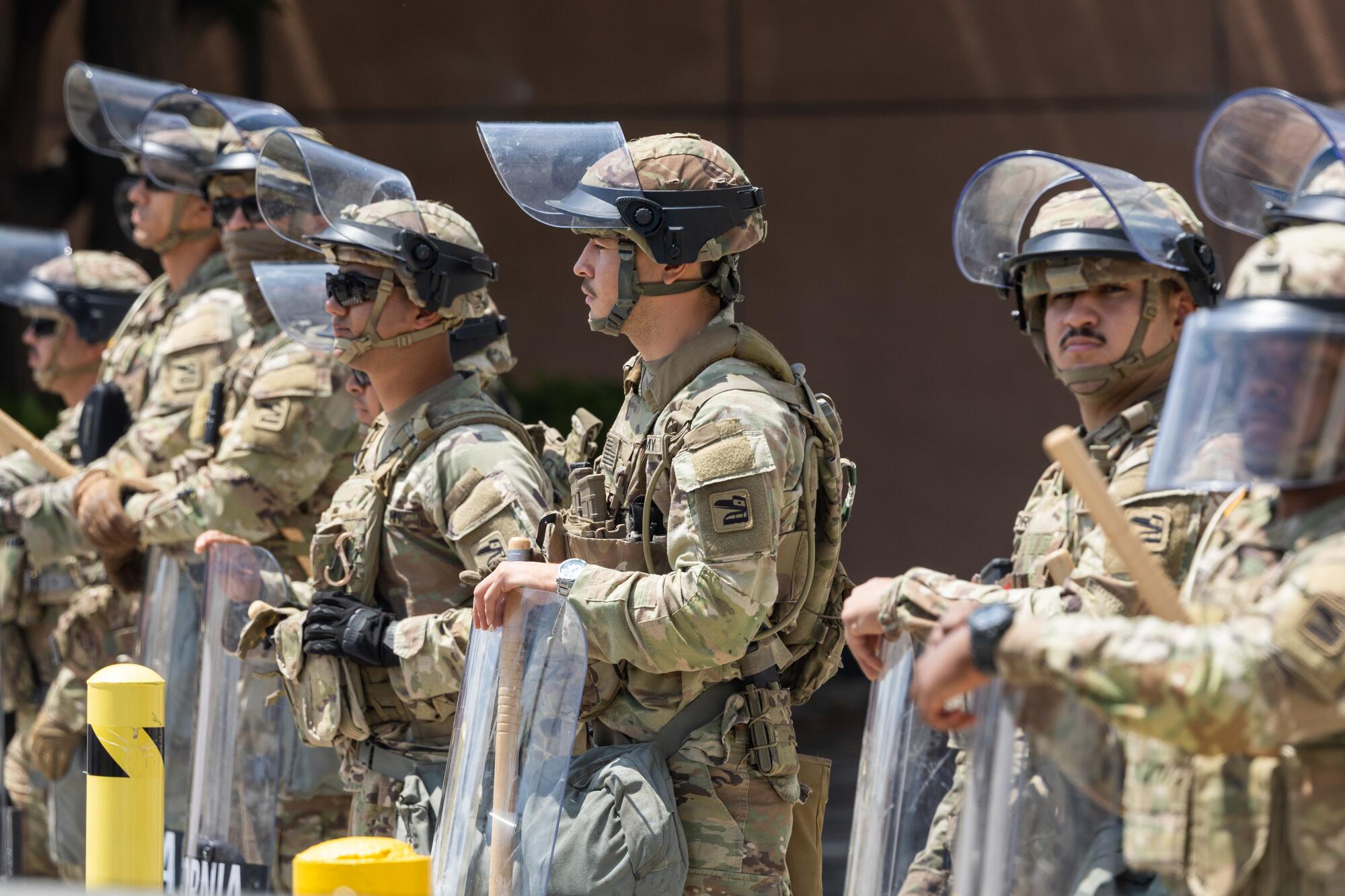 National Guard members stand in a line in front of a building