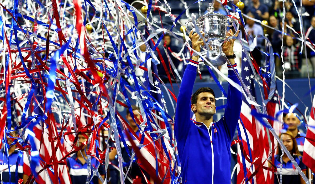 Novak Djokovic celebrates with the winner's trophy after defeating Roger Federer during their Men's Singles Final match on Sunday.