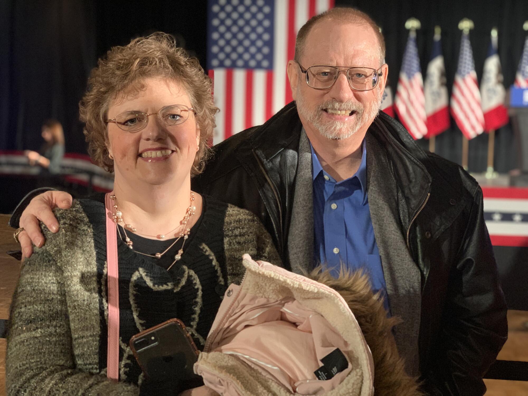 A man and a woman with American flags in the background