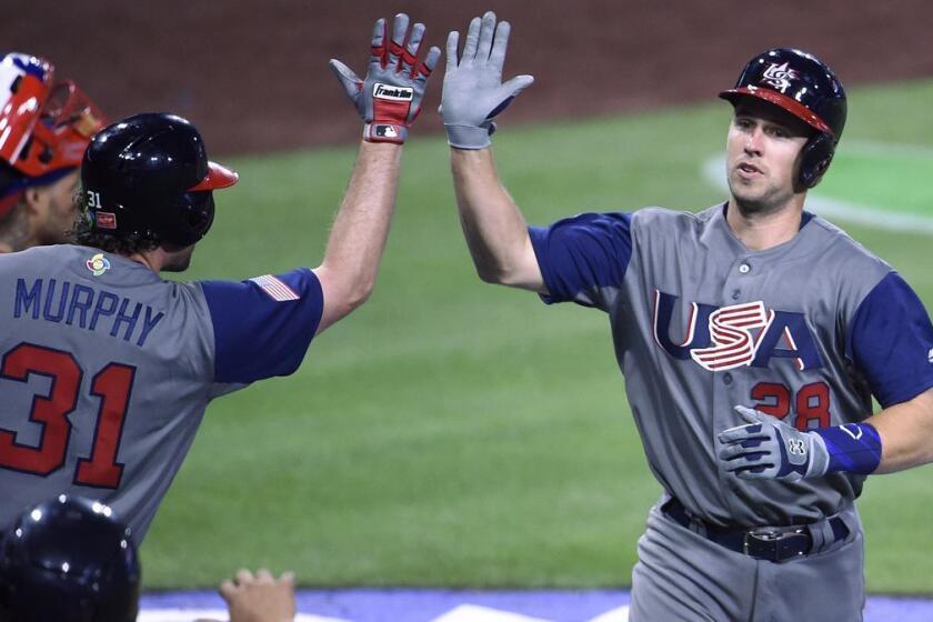 Buster Posey (28) is congratulated by Daniel Murphy after hitting a solo home run for the U.S. during the fifth inning of a World Baseball Classic game against Puerto Rico in San Diego on Friday.