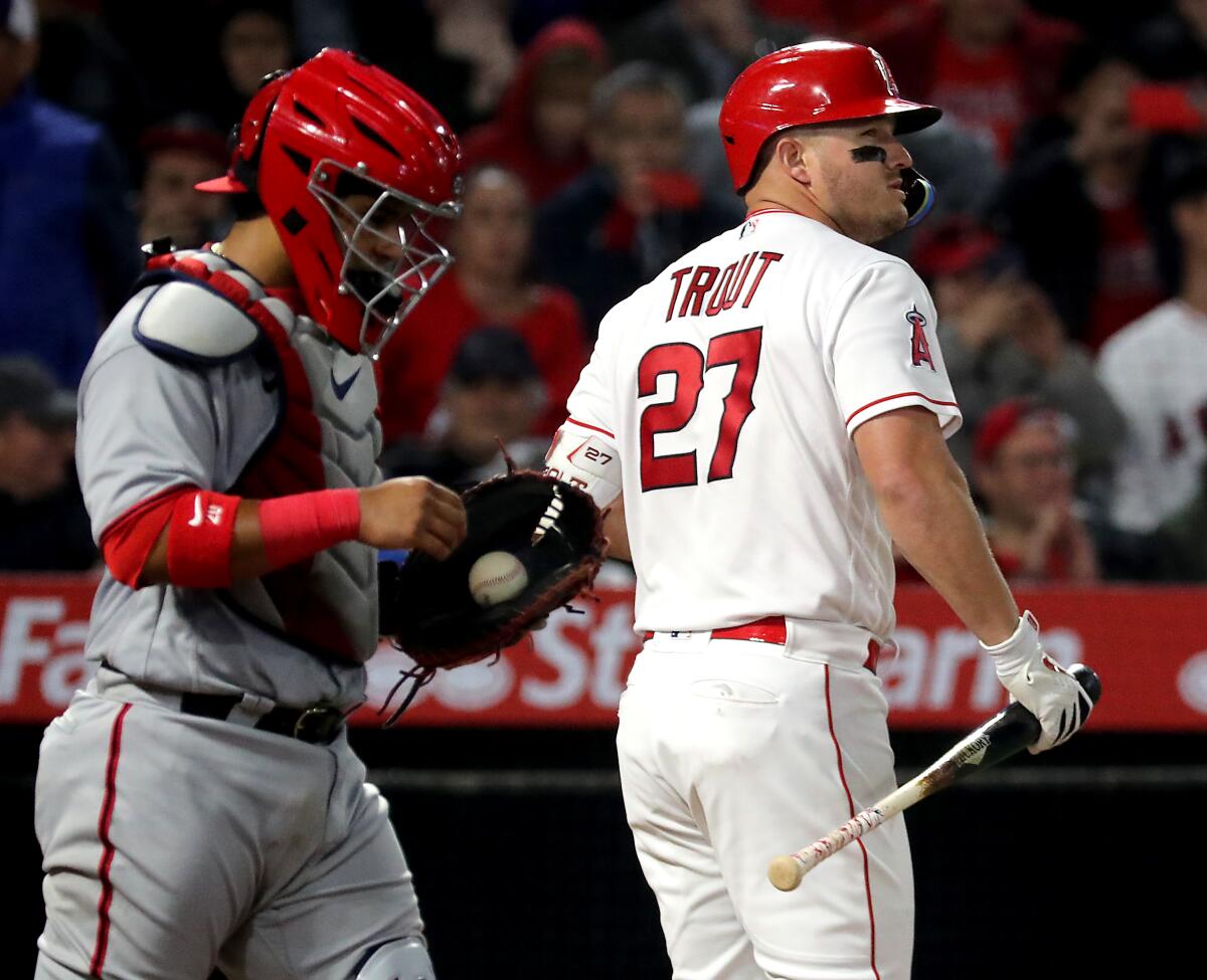 Angels star Mike Trout, right, strikes out to end the game against the Nationals on Monday.
