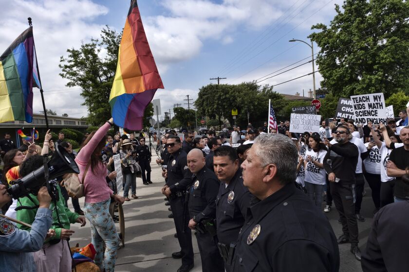 Los Angeles police officers separate protestors at the Saticoy Elementary School in the North Hollywood section of Los Angeles on Friday, June 2, 2023. Police officers separated groups of protesters and counter-protesters outside the Los Angeles elementary school that has become a flashpoint for Pride month events across California. (AP Photo/Richard Vogel)