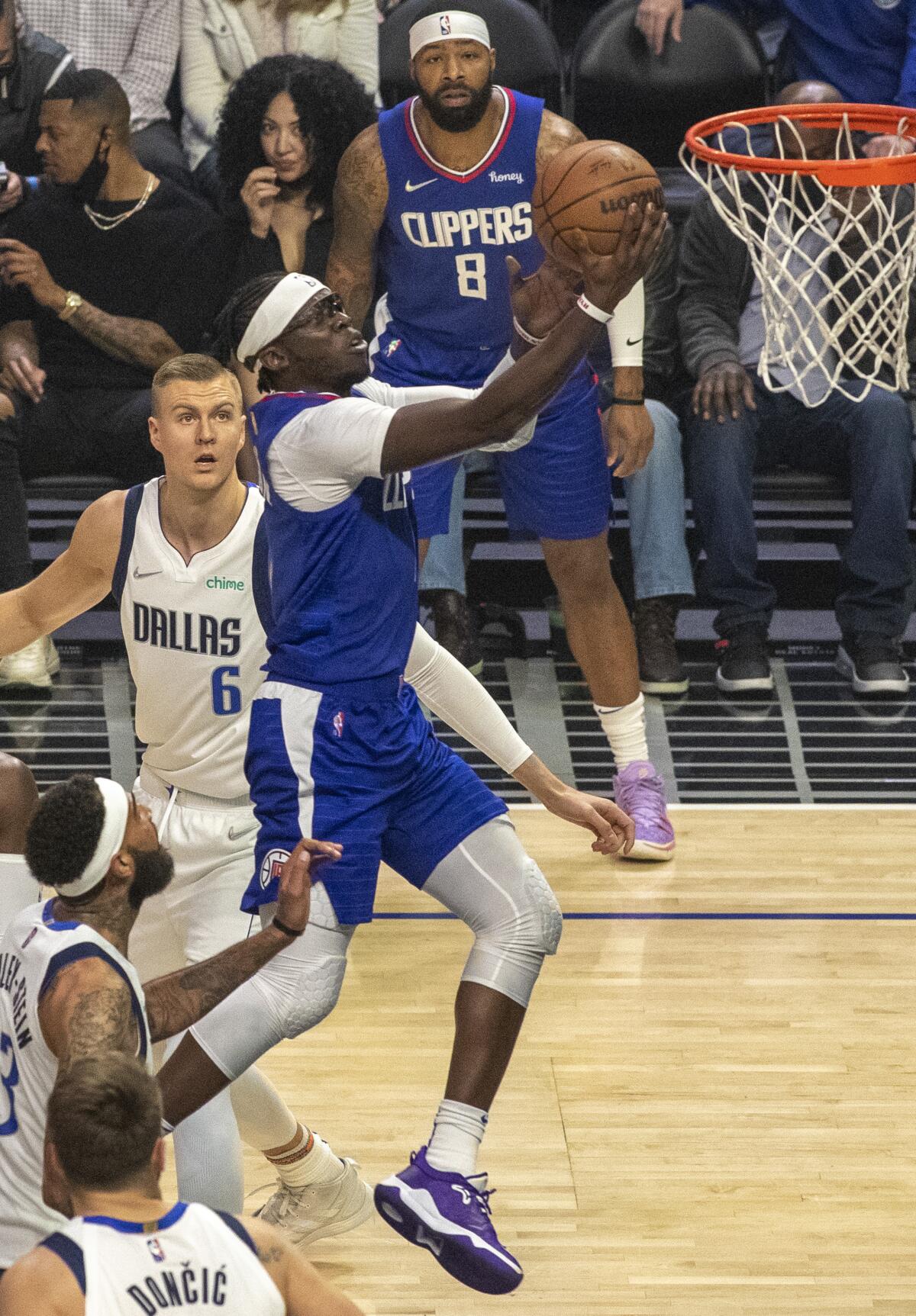 Clippers guard Reggie Jackson takes it to the basket past Dallas Mavericks center Kristaps Porzingis