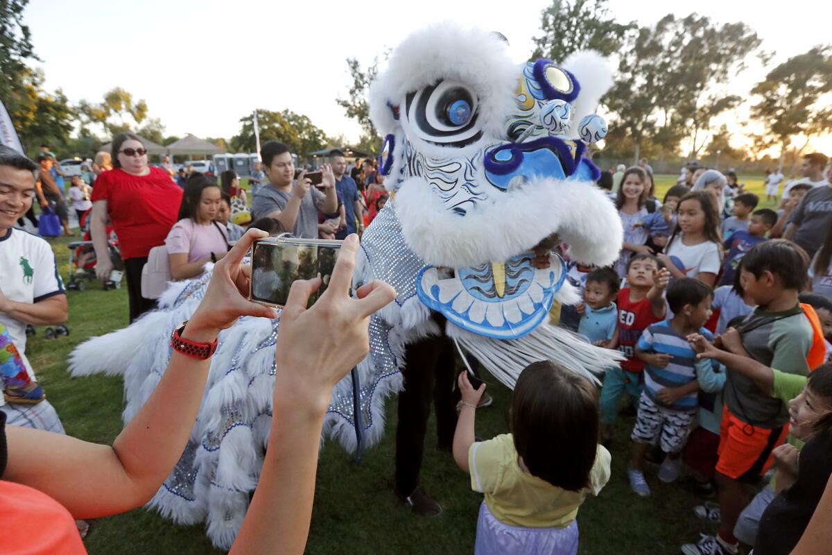 Dragon dancers entertain dozens of children during Saturday's Moon Festival at Mile Square Regional Park in Fountain Valley. Organized by Orange County Supervisor Andrew Do, the celebration is a tradition where families and friends come together, eat mooncake and watch the moon at its largest and brightest point of the year.