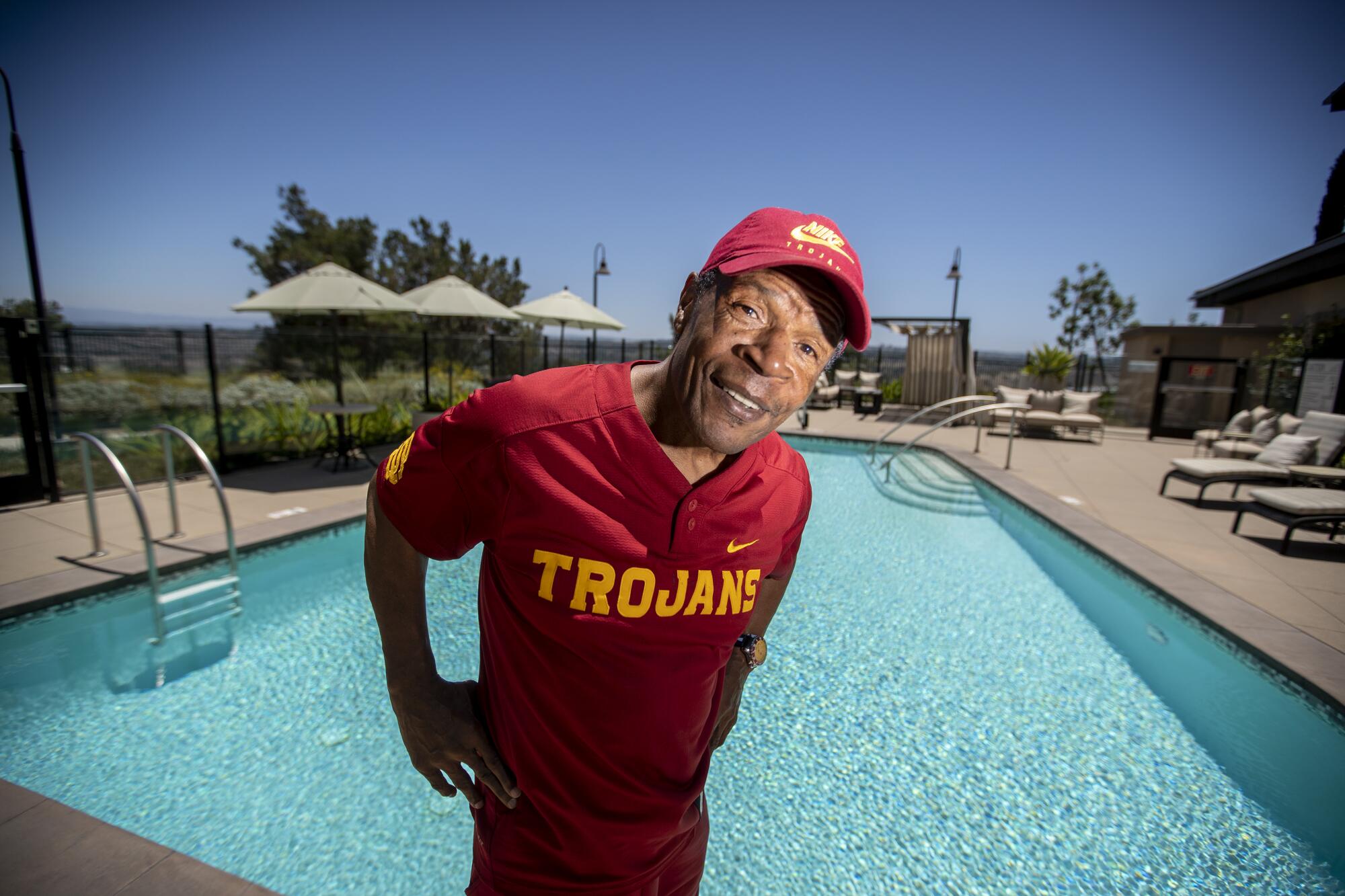 Charles White stands in front of a pool at the assisted-living facility in Orange County where he resides.