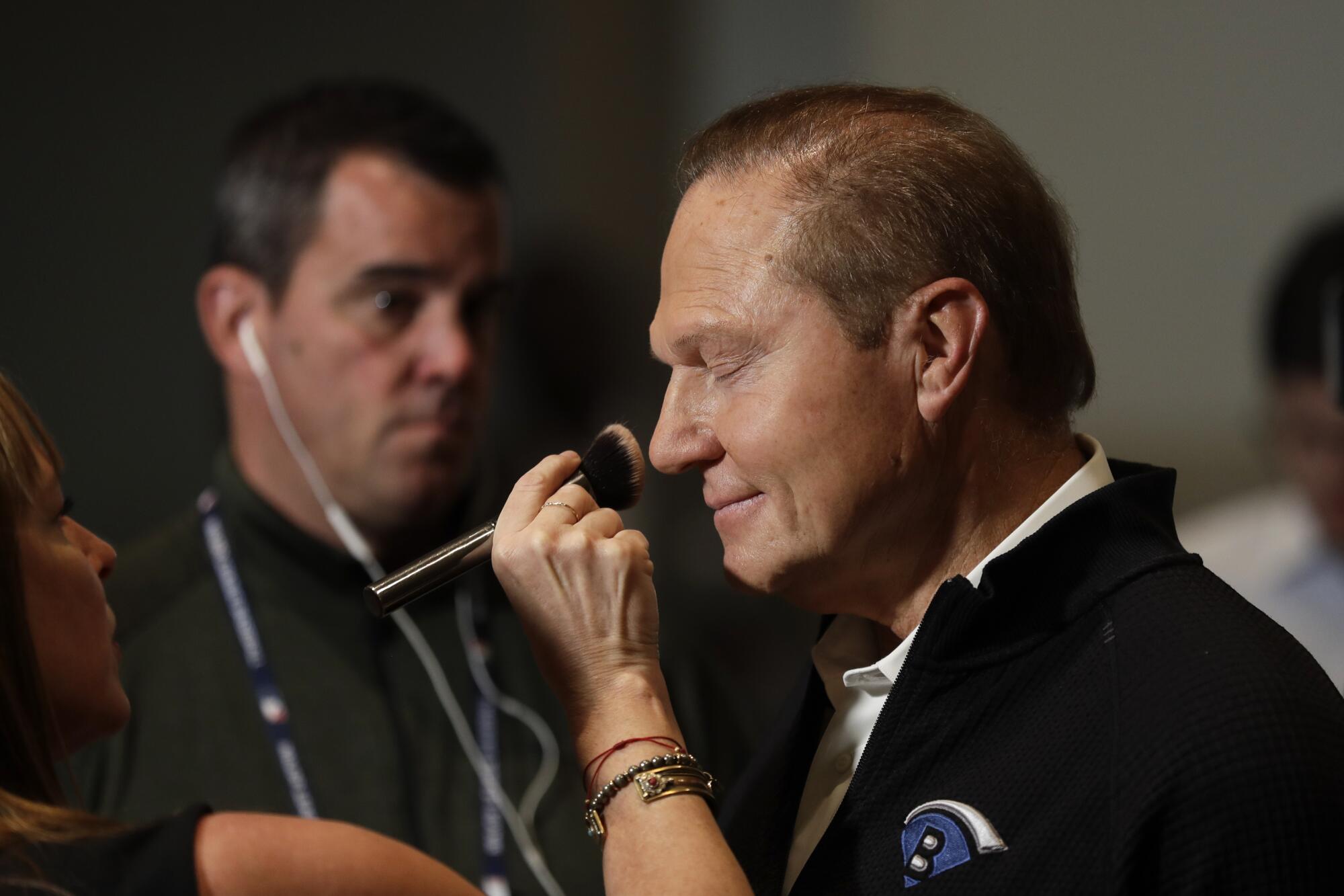 Scott Boras closes his eyes as makeup is applied to his face for a TV interview at the baseball winter meetings Dec. 10, 2019