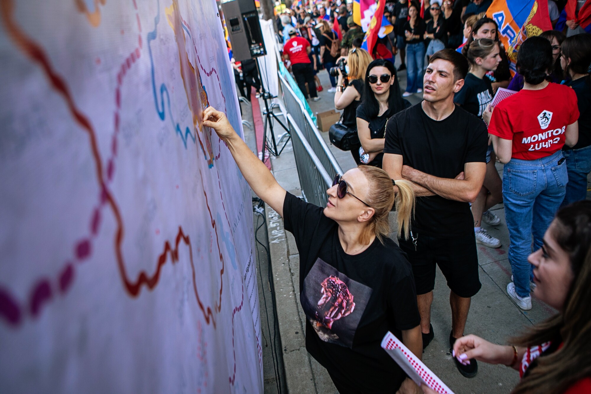 A woman places a red dot on the map