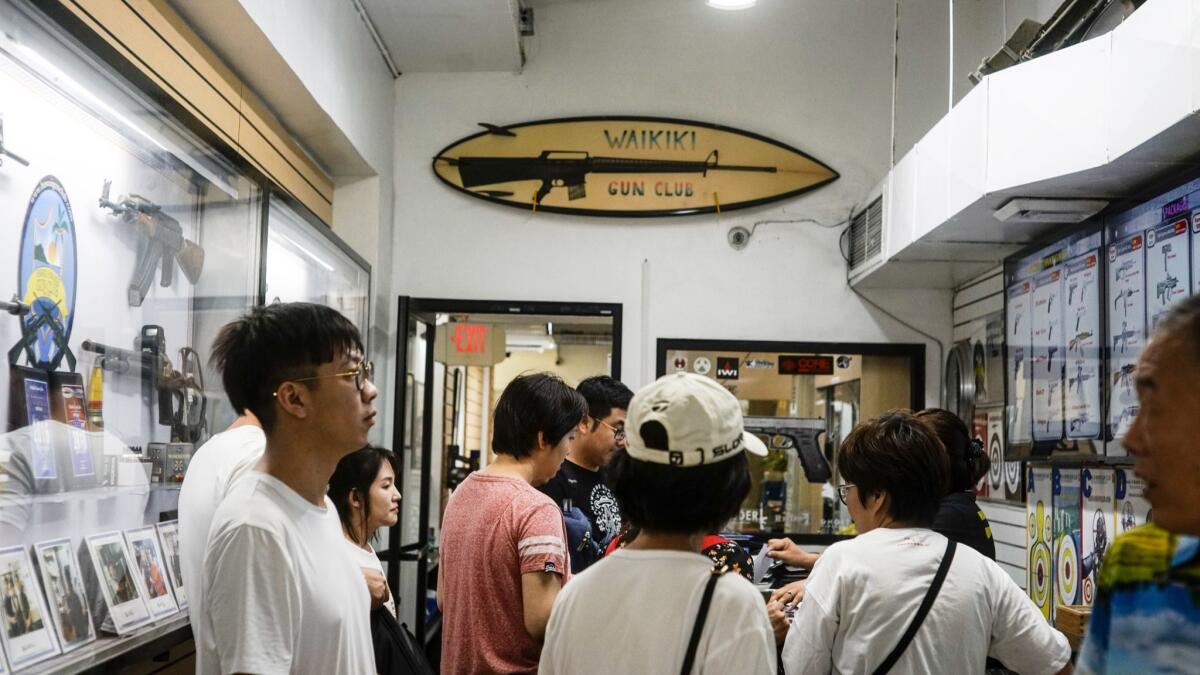A Chinese tour group waits to fill out paperwork before entering the shooting range at the Waikiki Gun Club. The place is well equipped with firearms, including AR-15s and AK-47s. Many of the store's visitors can't shoot, or even see, these weapons in their home countries.