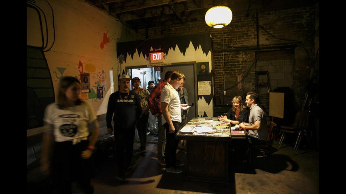 Owner Jim Smith, right, hands out tickets as patrons arrive at the Smell on June 2.