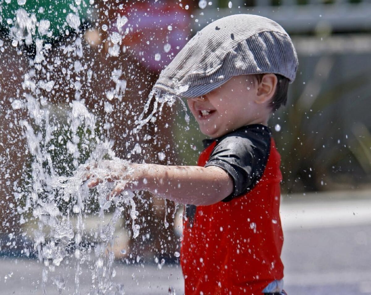 Santino Siesliga, 2 of Toluca Lake, cools down at the Pacific Park fountains in Glendale on Friday.