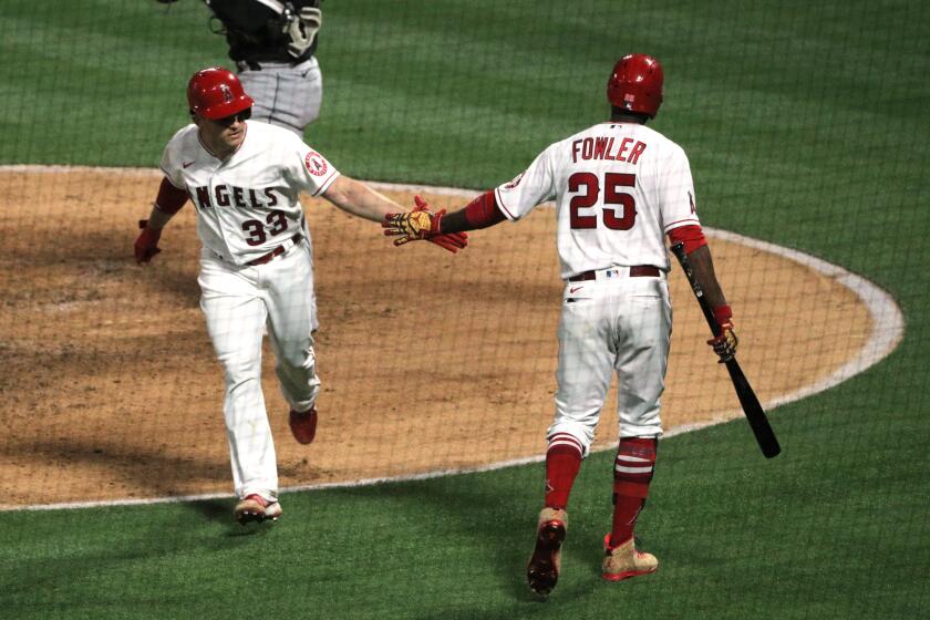 Angels catcher Max Stassi is greeted by right fielder Dexter Fowler after hitting a solo home run in the fifth inning.