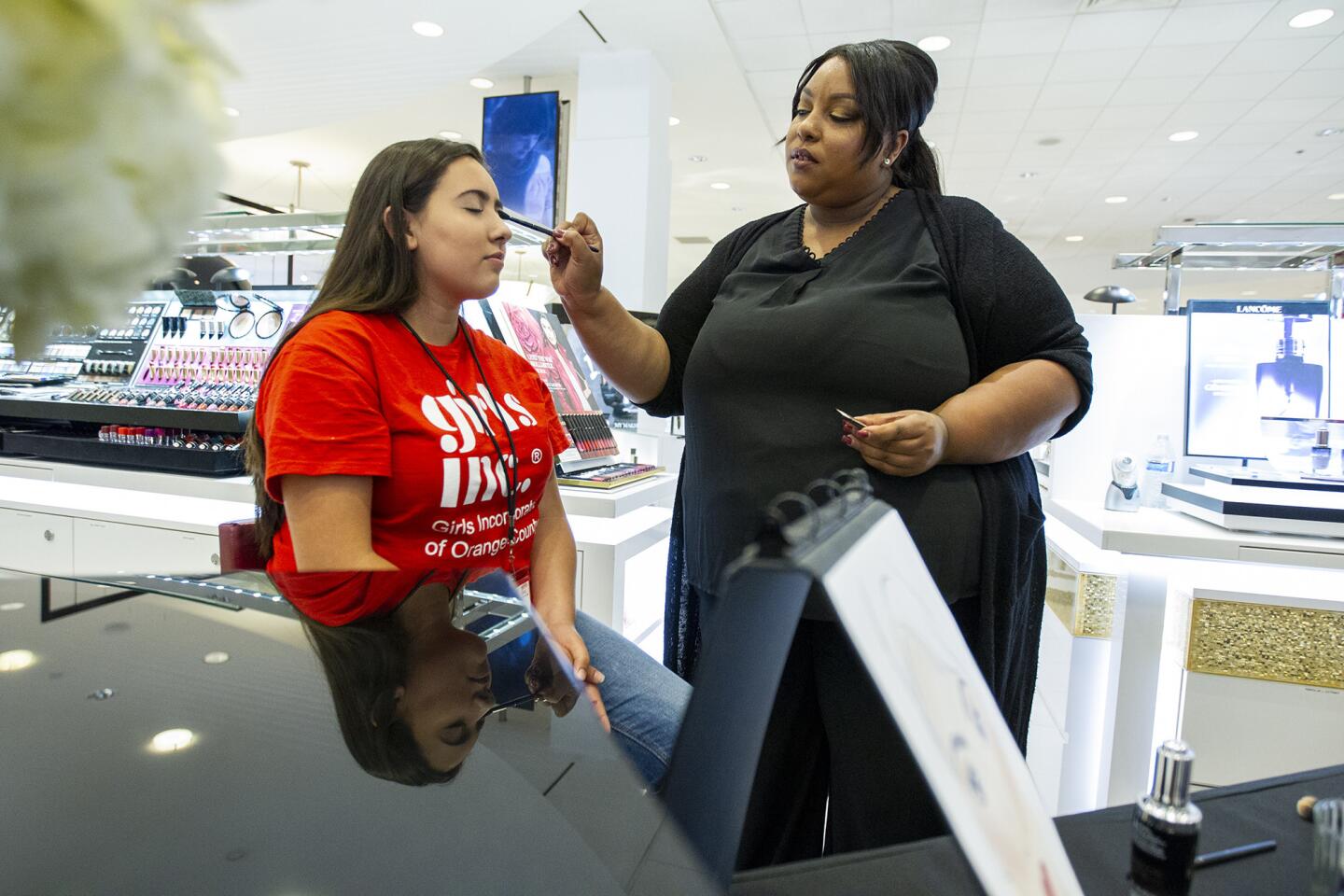 Natalie Martinez, 17, left, has her makeup done by Monique Coghlan during a makeup seminar for 85 girls from Girls Inc. Orange County's Externship Program at Macy's in South Coast Plaza on June 27.