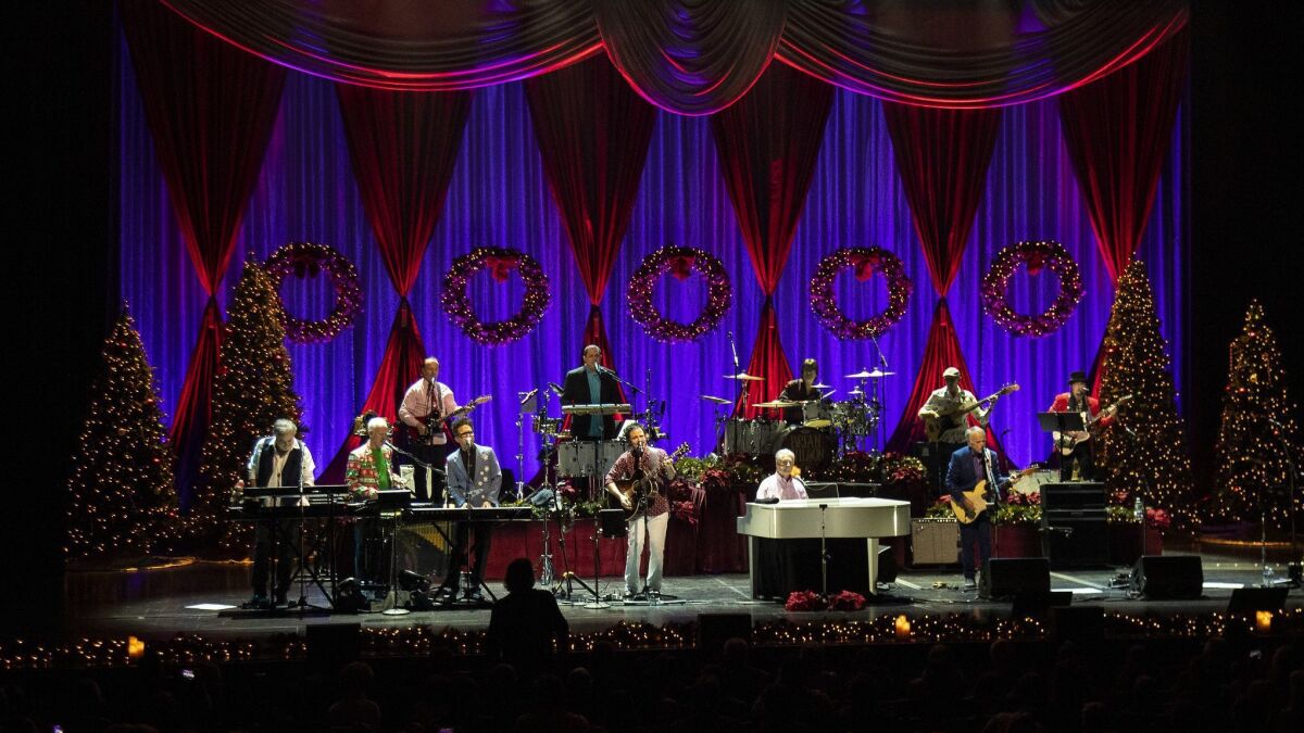 Beach Boys co-founder Brian Wilson, at the piano, sings hits from the Beach Boys' 1964 Christmas album with his band at the Fred Kavli Theatre on Thursday in Thousand Oaks.