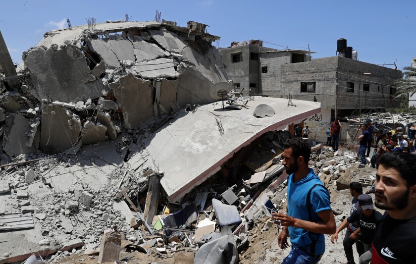 People inspect the rubble of a destroyed residential building which was hit by Israeli airstrikes, in Gaza City, Wednesday, May 12, 2021. (AP Photo/Adel Hana)