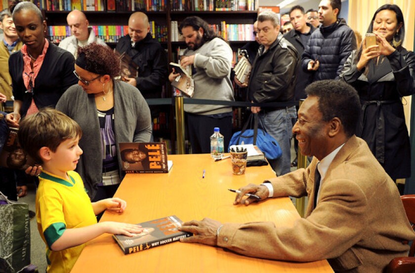 Pele talks with a young fan during a book signing at a Barnes & Noble in New York to promote "Why Soccer Matters."