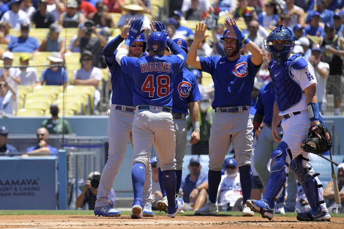 Chicago Cubs' P.J. Higgins is congratulated after hitting a grand slam as Dodgers catcher Will Smith stands at the plate.