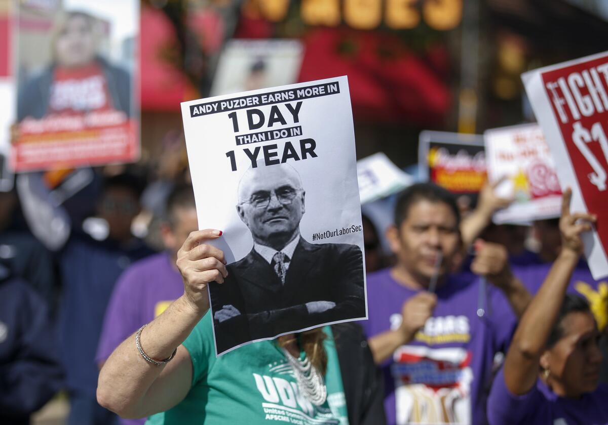 Fast-food workers gather in front of the CKE Restaurants corporate offices in Anaheim to protest before a Senate vote to confirm Andy Puzder as Labor Secretary.