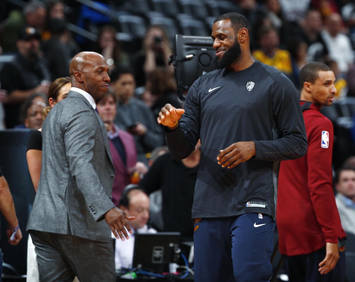 LeBron James greets broadcaster and retired NBA player Chauncey Billups during a Cavaliers playoff game in 2018.