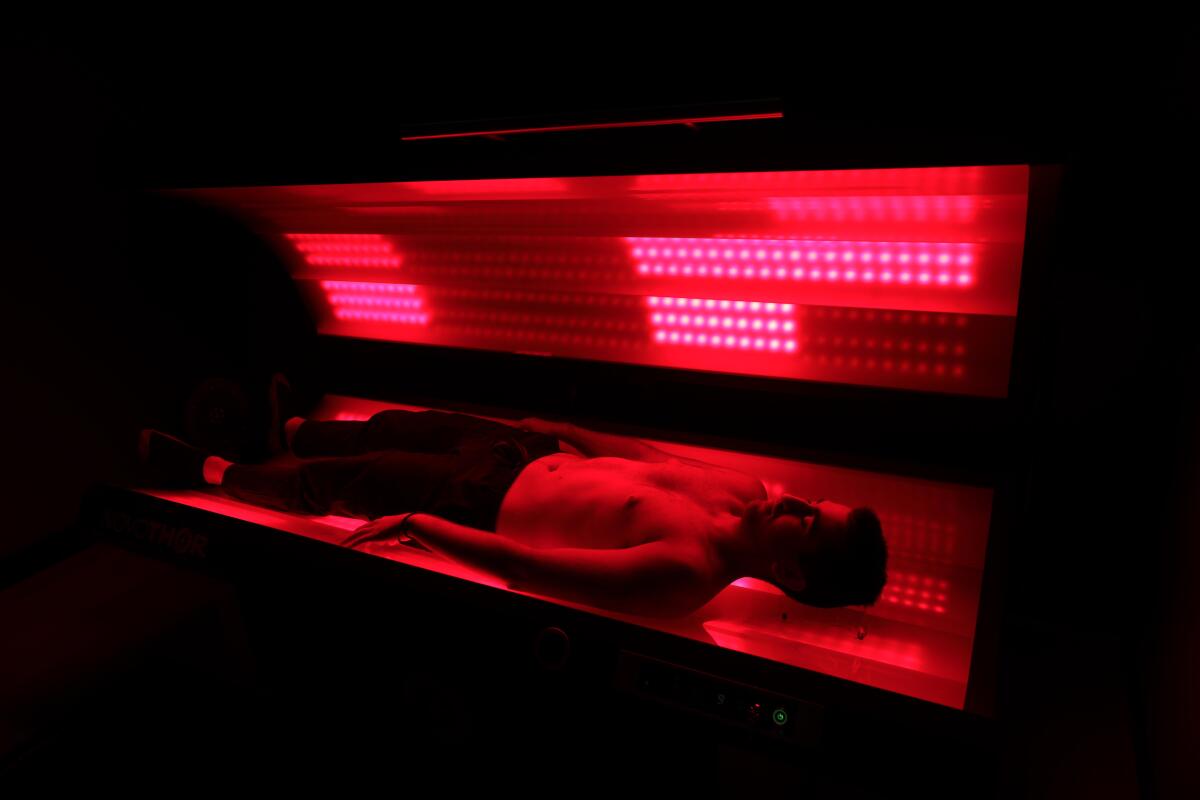 A man demonstrates the use of red light therapy.
