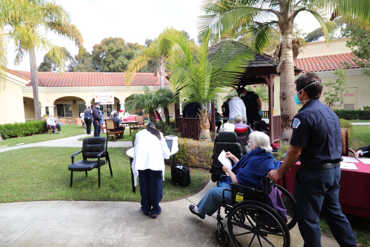 Nursing home residents in wheelchairs line up outdoors