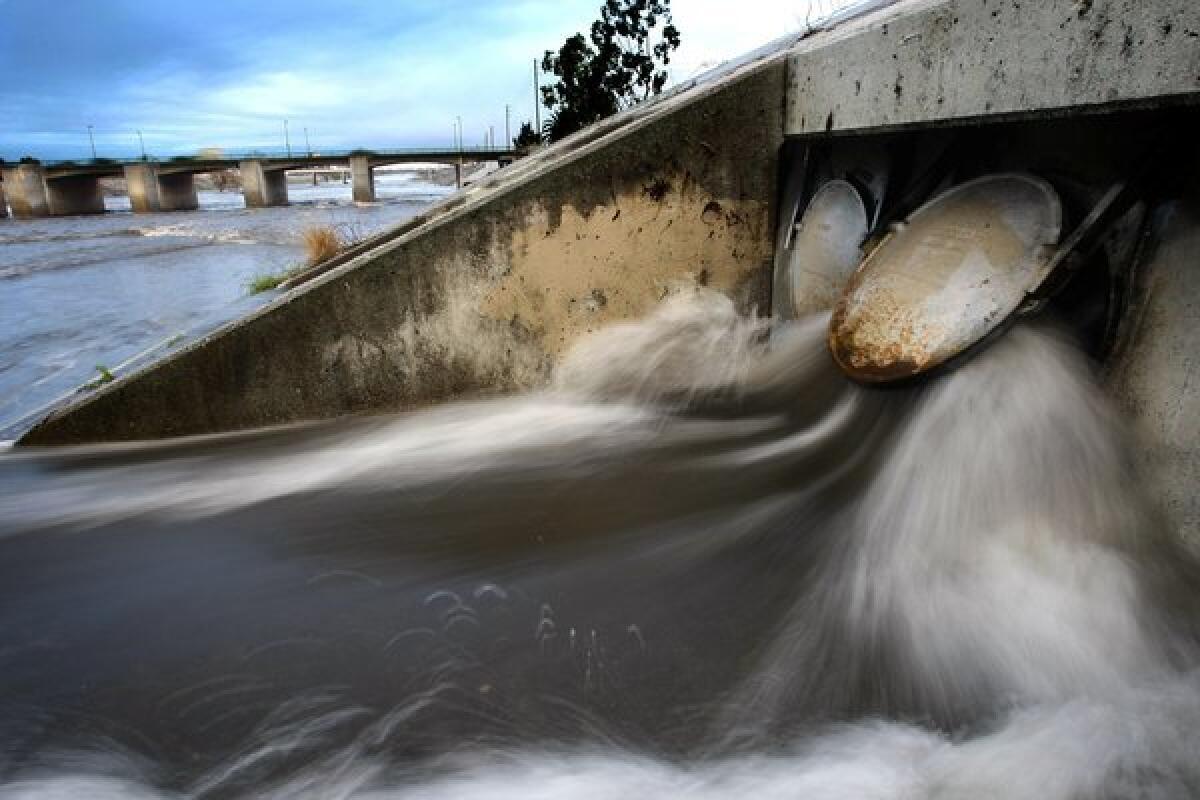 Storm water bursts through heavy steel gate valves and flows into the Los Angeles River in Long Beach. The concrete-lined river carries rainwater beneath the Willow Street Bridge and out to the Pacific.