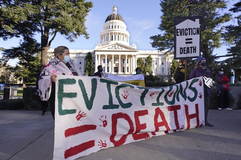 Demonstrators in Sacramento hold a banner calling for eviction protections 