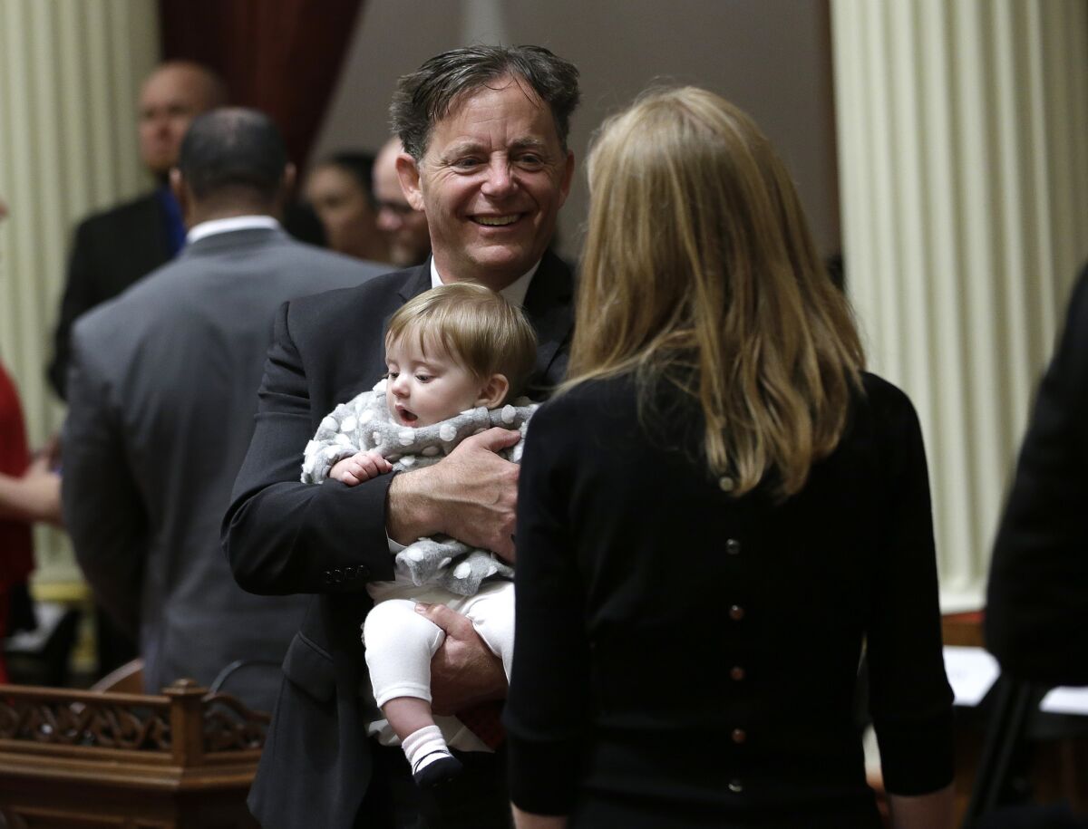 Freshman state Sen. Josh Newman (D-Fullerton) holds his daughter Cecily as he waits to be sworn in to the state Senate in December.