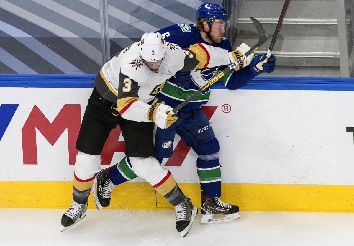 Vancouver Canucks' Brock Boeser (6) is checked by Vegas Golden Knights' Brayden McNabb (3) during first-period NHL Western Conference Stanley Cup playoff action in Edmonton, Alberta, Thursday, Sept. 3, 2020. (Jason Franson/The Canadian Press via AP)