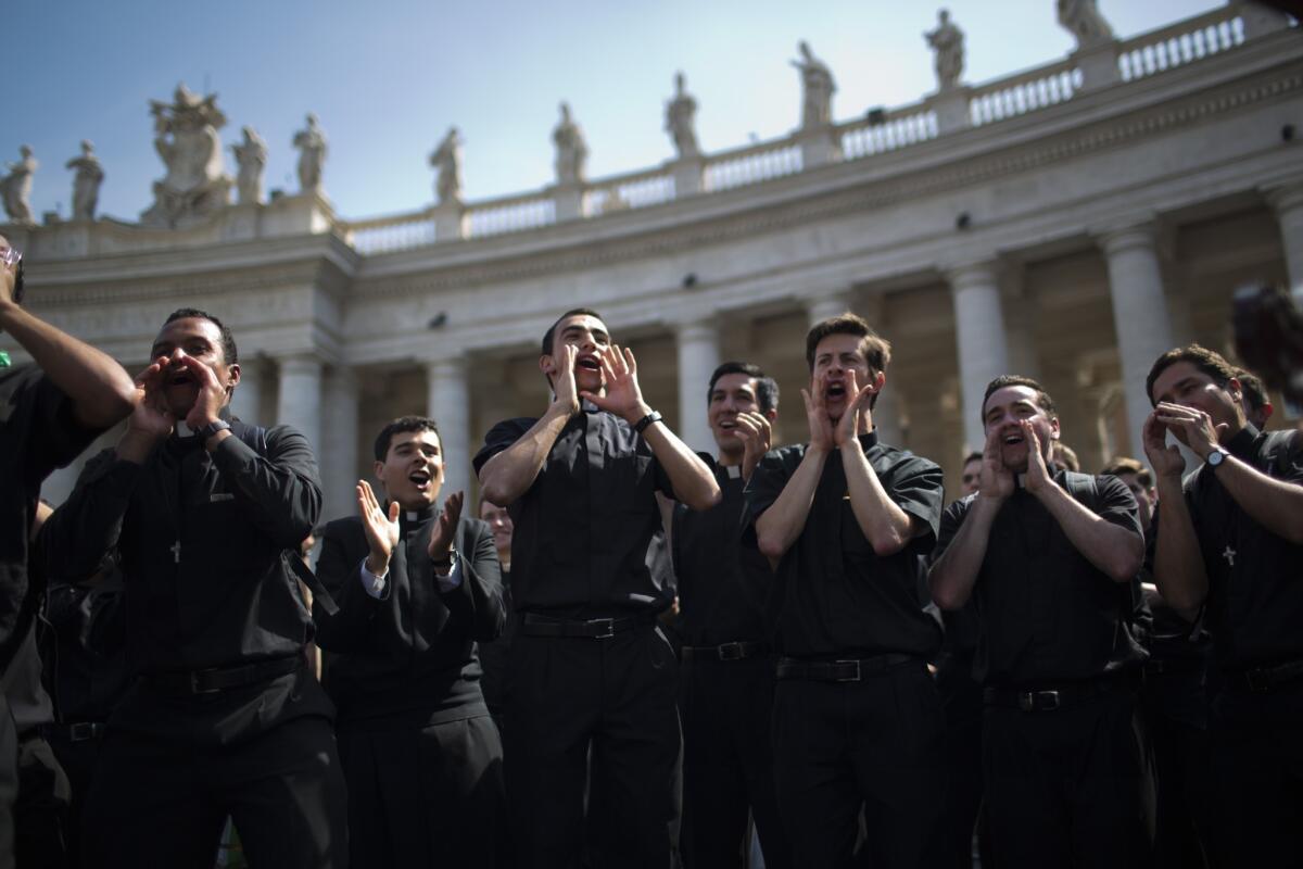 Priests sing and dance in St. Peter's Square at the Vatican on Saturday.