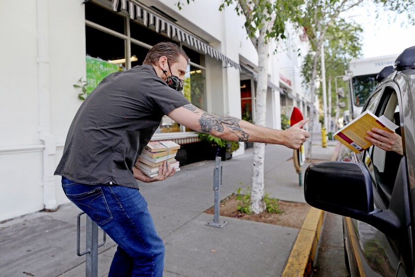 Jason Cohen delivers a book to a customer at curbside at the Bookshop Santa Cruz
