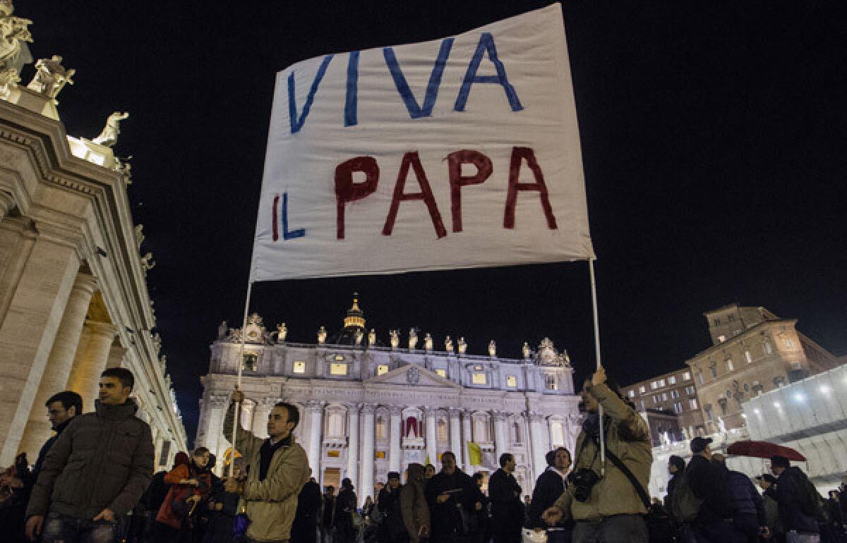 Faithful in St. Peter's Square hold up a message to Pope Francis, the 266th pontiff of the Roman Catholic Church.