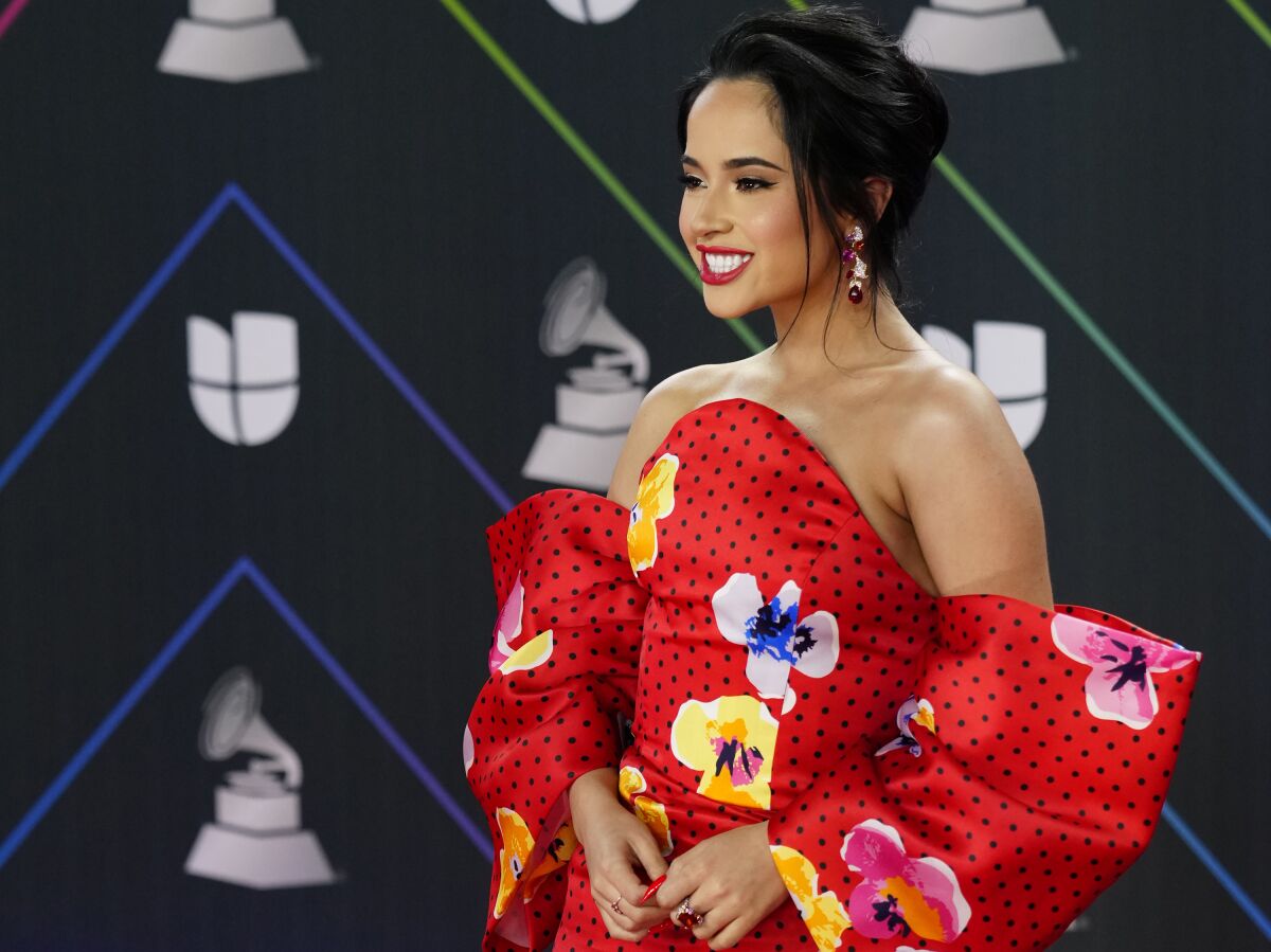 Mujer con un vestido floral rojo en una ceremonia de entrega de premios