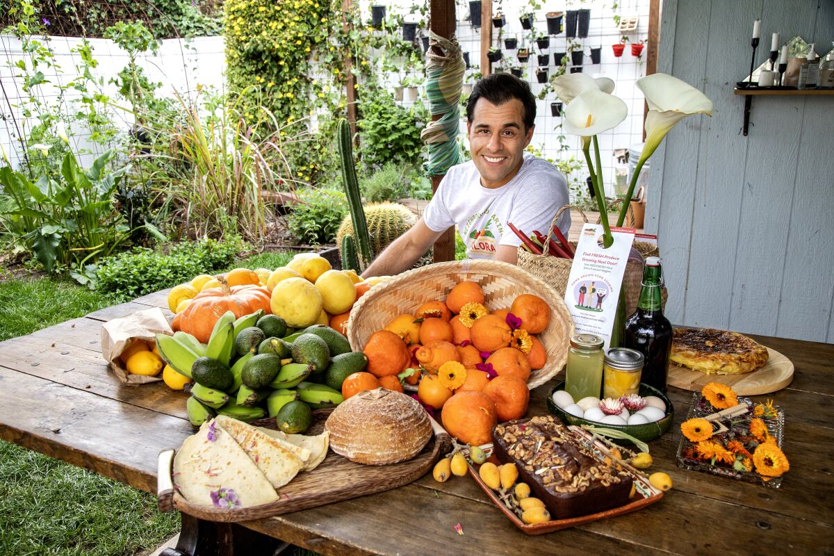 Ryan Xavier sits at a table laden with bread, fruit and other edible items.