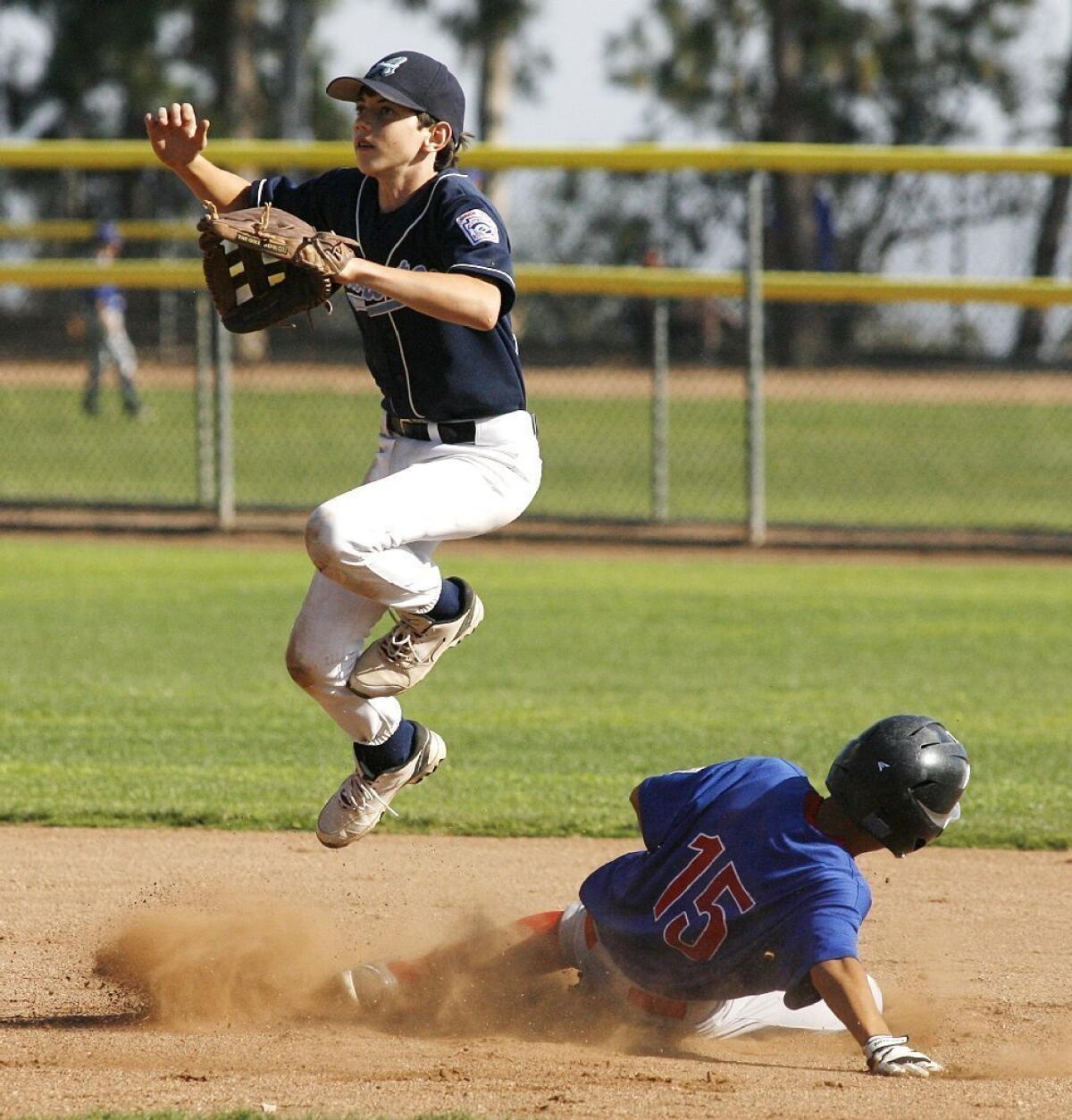 Crescenta Valley Junior Augusta's Drew Atherton jumps over Burbank Junior Cubs' Matthew Shaugabay in a 2-0 CV win.