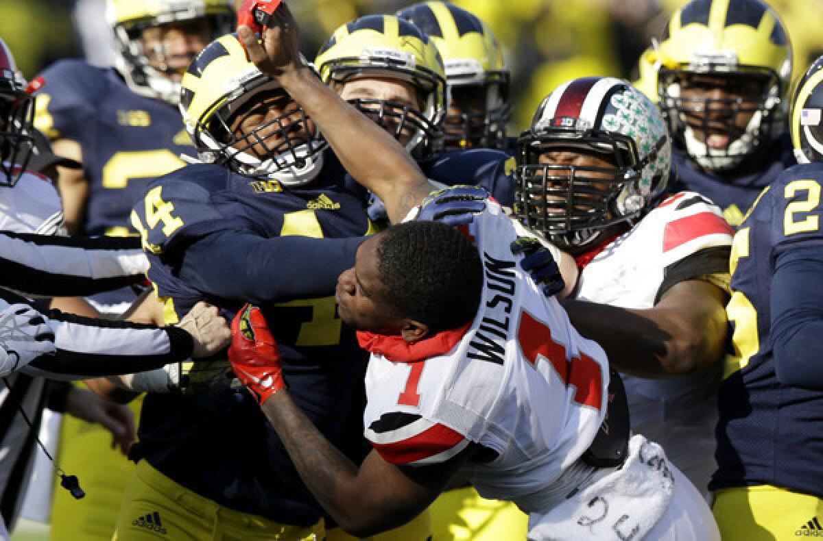 Ohio State's Dontre Wilson (1) is held back by Michigan defensive back Delano Hill (44) as the two teams scuffle during the second quarter of their game Saturday.