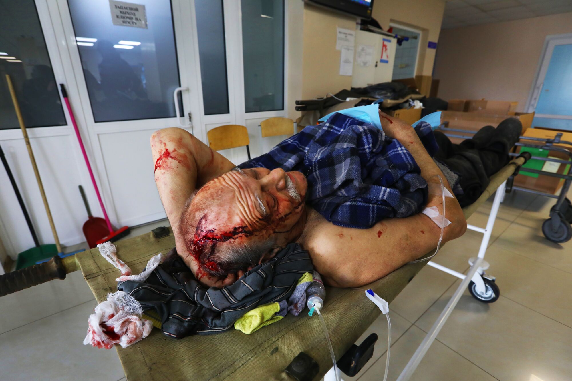 A year of war: Los Angeles Times photographers document the battle in Ukraine 5 A man with a bloody head wound lies on a stretcher