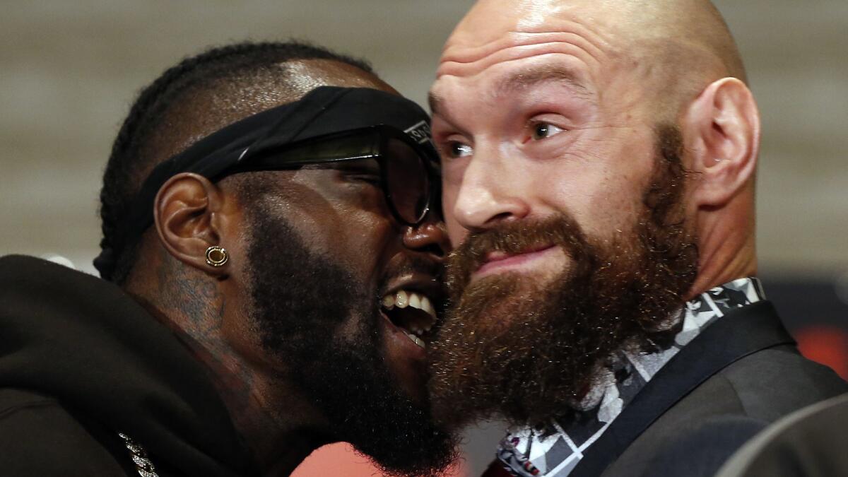 Deontay Wilder, left, and Tyson Fury exchange words at a news conference on Nov. 28.