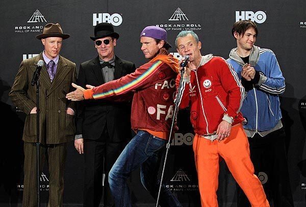 Red Hot Chili Peppers drummer Chad Smith, center, introduces former members Jack Irons, left, and Cliff Martinez with Mike "Flea" Balazary, second from right, and Josh Klinghoffer before the group was inducted into the Rock and Roll Hall of Fame on Friday, April 13, 2012, in Cleveland.